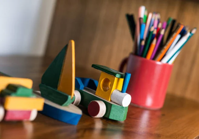 Children's wooden toys and pencils on table